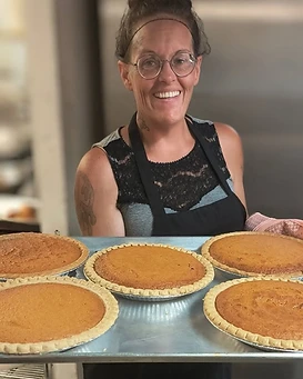 Sweet T’s team member presenting several homemade pies