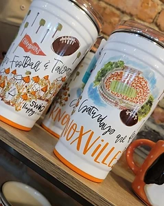 Illustrated football tumbler displayed against a brick wall