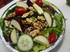Fresh prepared salad with apples, cucumbers, tomatoes and mixed nuts