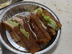 Prepared toasted sandwich with lettuce in a foil takeout tray