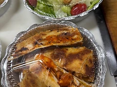 Prepared salad and folded sandwiches on a kitchen counter