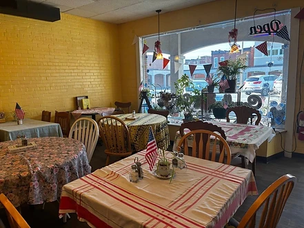 Camellia City Cafe dining room with its real furniture, floral table coverings, decorations, plants, and street view