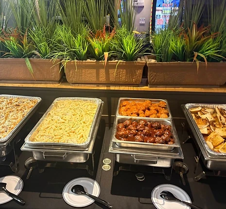 Hot buffet setup with chafing dishes and several prepared foods