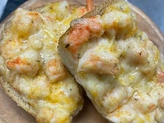 Baked seafood toast on a wooden serving board
