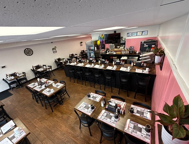 South Glastonbury dining room with café seating, counter seating, pink walls and wood flooring