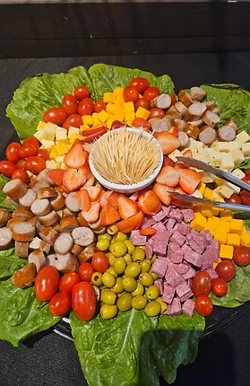 Large platter with meats, cheese, fruit, vegetables, and olives