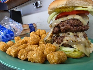 A stacked burger served with crisp tater tots