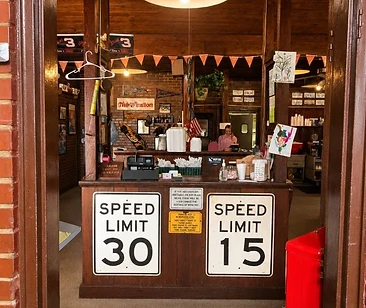 Front counter framed by brick and vintage road signs