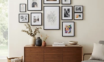 Example of a gallery wall arrangement of framed artwork above a console table