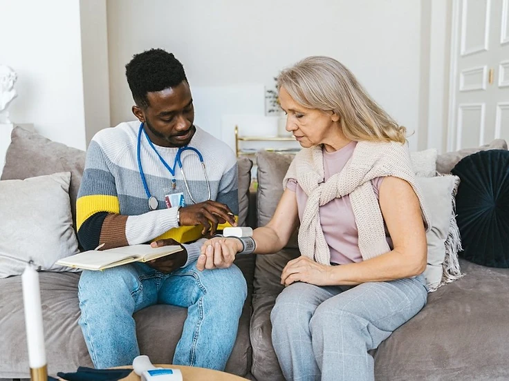 A home health nurse checking on an older patient
