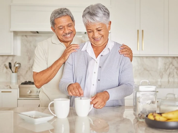 Two people smiling together in a kitchen