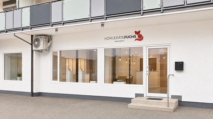 Schaufenster-Fassade von Hörgeräte Fuchs in Traunreut mit Logo und Eingangstür