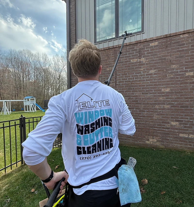 Elite Window Cleaning technician cleaning a residential window