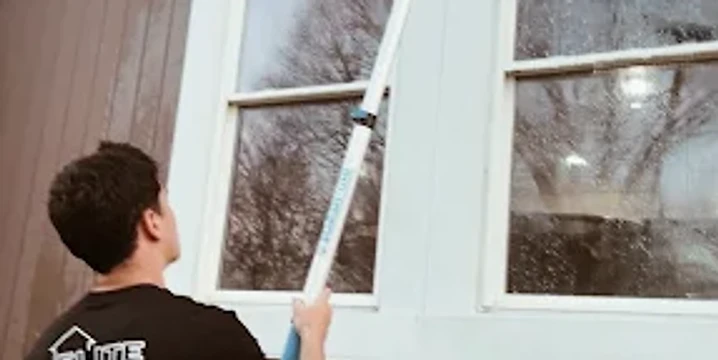 Elite technician cleaning a residential window with a water-fed pole