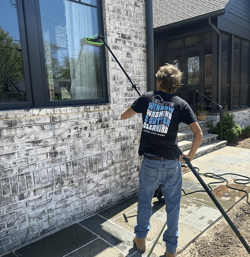 Elite Window Cleaning professional cleaning a residential window