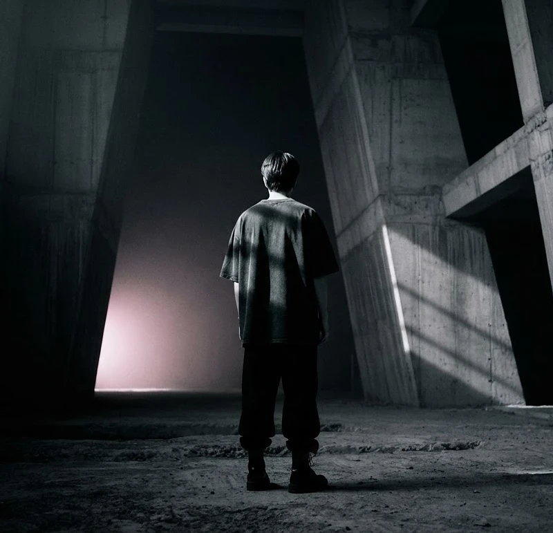 A lone figure in a brutalist space