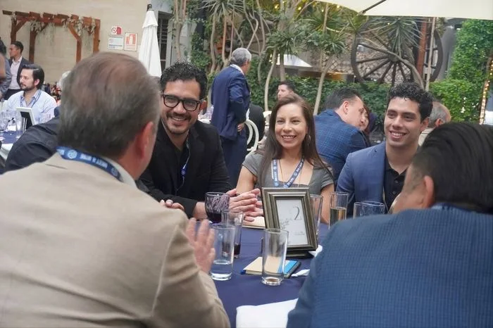 Empresarios conversando alrededor de una mesa en un Meet & Wine de Mekanexia