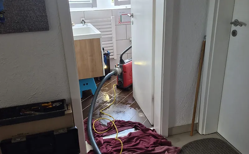 Arbeitsfoto: Öffnen und Reinigen eines Abflusssiphons