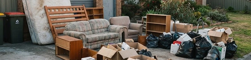 Utility trailer loaded with household furniture in a residential driveway