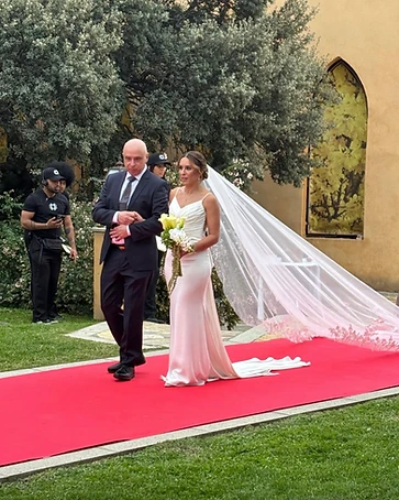 Novia recorriendo una alfombra roja con su padre