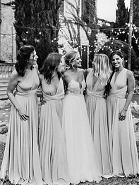 Novia con damas de honor bajo las luces del jardín