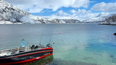 Kvaernø 630 fishing boat anchored in a clear Arctic fjord at Ersfjordbotn