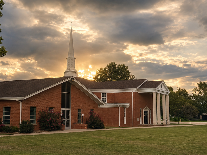 Abundant Life Church brick building with white steeple at sunset
