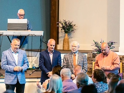 Church leaders stand among the congregation during a Sunday gathering