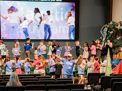 A wide view of children gathered for a kids ministry event in the sanctuary