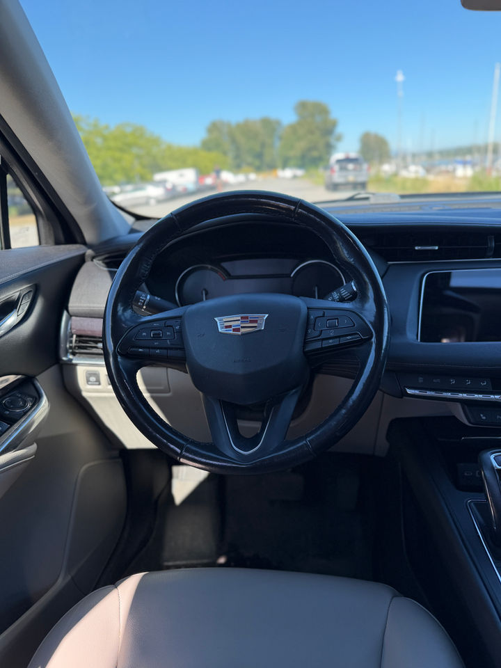 Black 2019 Cadillac XT4, the dash and steering wheel from the driver’s seat, looking out through the windshield.