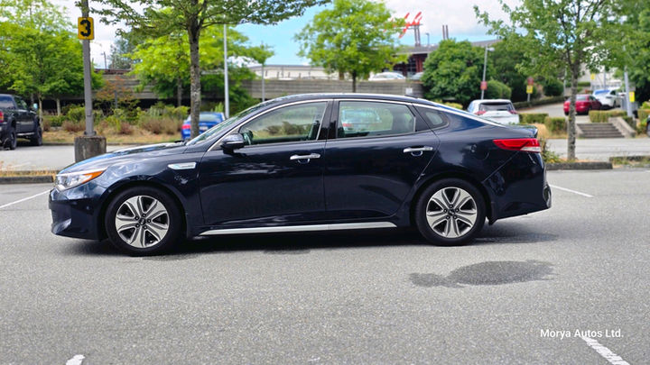 2017 Kia Optima in dark blue, passenger-side profile, on a dealer’s lot.