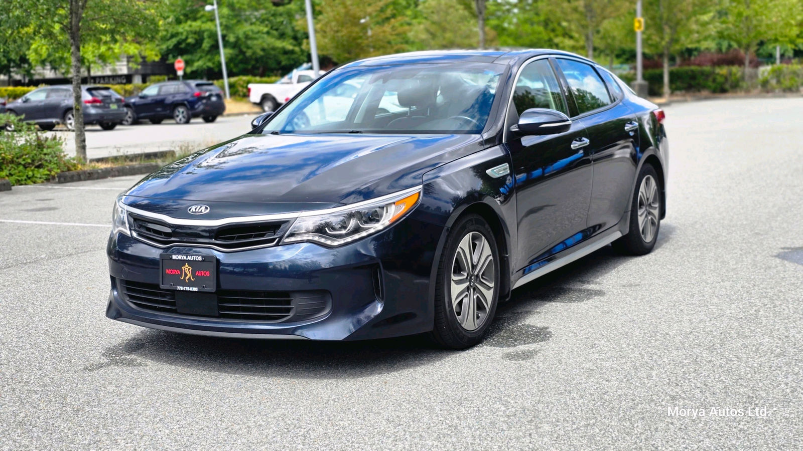 2017 Kia Optima in dark blue, front three-quarter view from the passenger side, on a dealer’s lot.