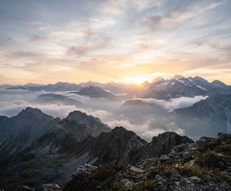 Picos de montanha tocando nuvens ao amanhecer