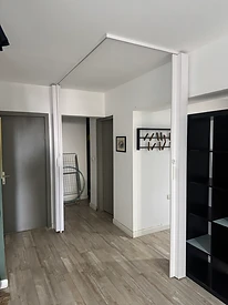 תקריב של המסילה העליונה הצמודה לתקרה, שדלת האקורדיון תלויה ממנה