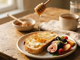 Raw honey drizzled over warm buttered toast and fresh fruit