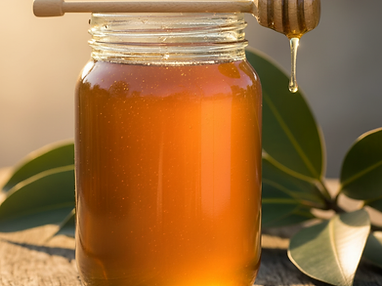 A glass jar of golden honey with a wooden dipper resting on weathered wood