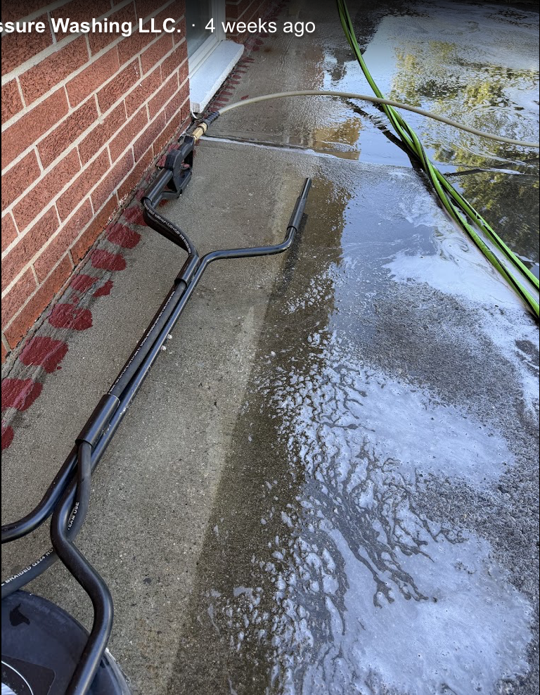 Concrete surface being pressure washed mid-clean