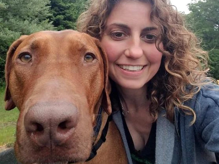 Friendly WAGS staff member with a happy golden retriever in-store