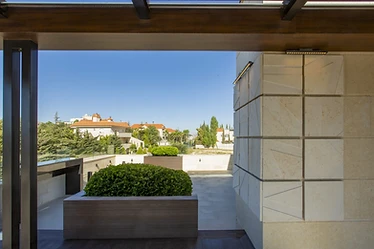 Framed view, roof terrace design, Amman: planter and stone-clad column under the pergola beam