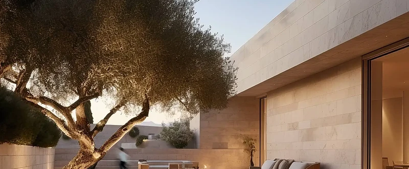 Courtyard of a Jeddah villa with limestone walls, reflecting pool, and mature olive tree
