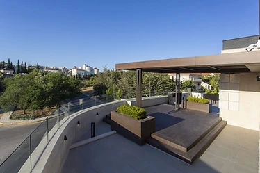 Roof by day, roof terrace design, Amman: glass balustrade, pergola, raised deck and two planters