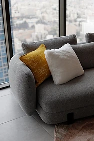 Living room detail, flat interior design, Amman: mustard and white cushions against the window light