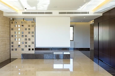 After: living hall, duplex interior design, Amman: cream marble floor, breeze-block screen, walnut units