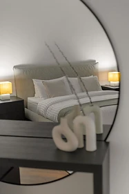 Primary bedroom, flat interior design, Amman: round mirror reflecting the bed, quilted circular headboard