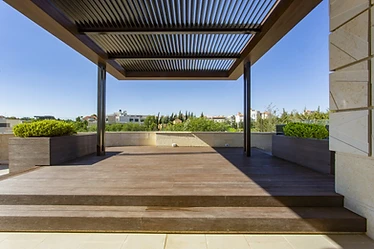 Pergola by day, roof terrace design, Amman: louvred roof, deck steps and a view over the city