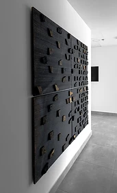 Basalt wall art, flat interior design, Amman: dark ribbed stone panel with embedded stone chips, hallway view