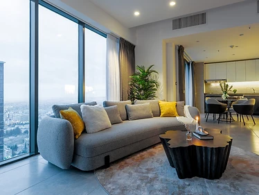 Living room, flat interior design, Amman: evening light, lit candle, desk nook visible by the window