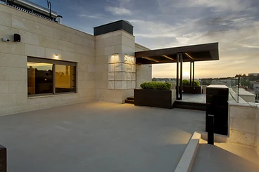 After: roof beside the house, roof terrace design, Amman: stone-clad wall, lit window, pergola
