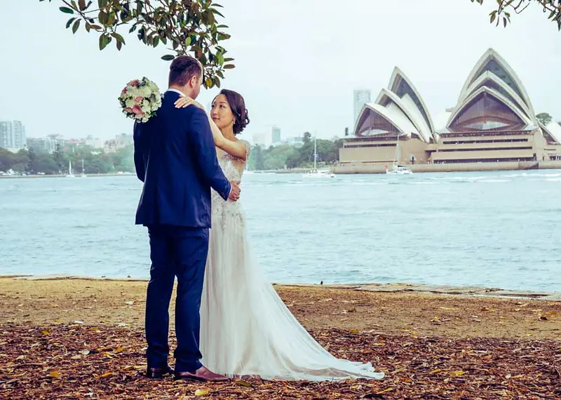 Happy couple standing before the iconic Sydney Harbour view at Pier One wedding venue