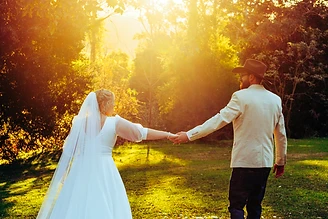 Amanda and Gareth standing in the lush green grounds of Riverwood Downs for their wedding